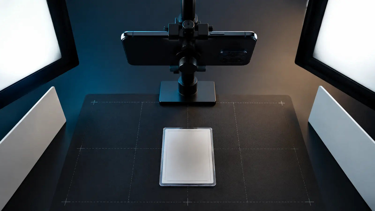 Carte TCG générique photographiée sous une lumière douce avec téléphone sur support et fond mat