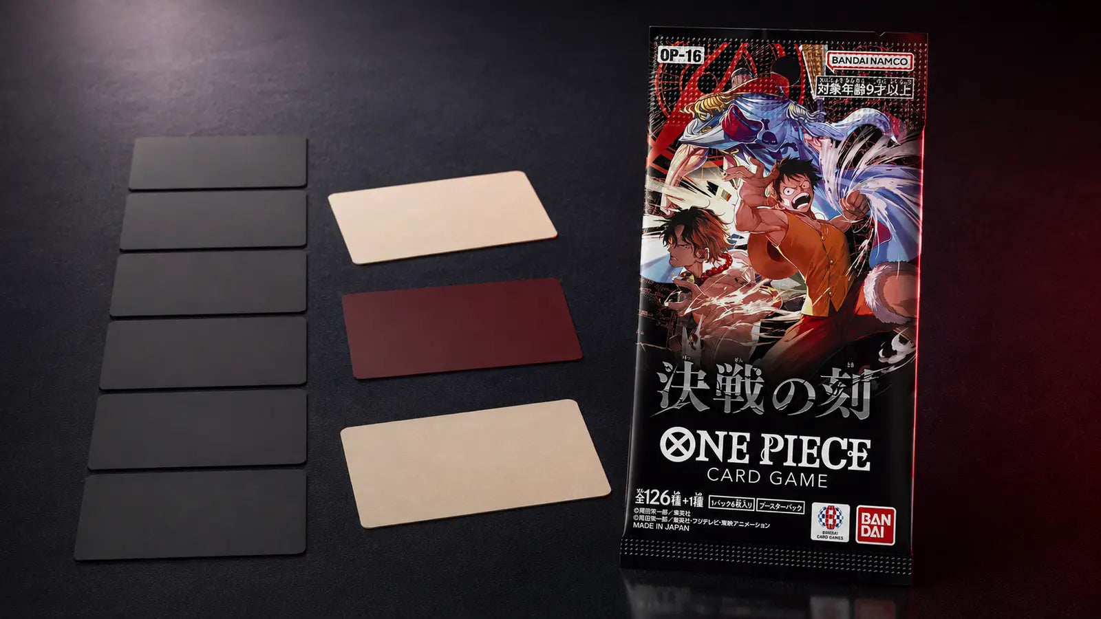 Sobre japonés One Piece Card Game OP-16 junto a cartas de recurso neutras sobre un tapete oscuro